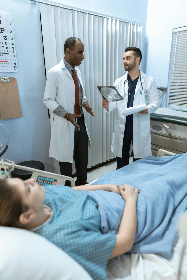 Medical professionals discussing x-ray results with a patient in a hospital room setting.