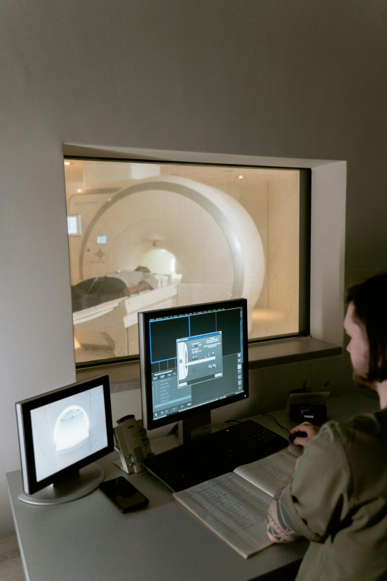 Health worker examines MRI scan data in a clinical setting.